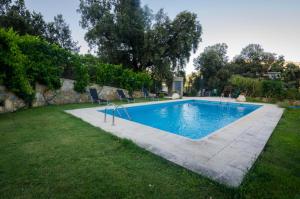 a swimming pool in a yard with chairs around it at Calar de la Sima in Yeste