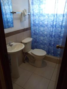 a bathroom with a toilet and a sink at Hotel Manantiales El Salvador in San Salvador