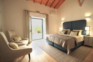 a bedroom with a large bed and a chair at Quinta da Luz - A Luxury Boutique B&B in Silves +32 photos