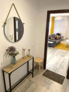 een woonkamer met een tafel en een spiegel bij Apartamentos Cantarería, Azahar in Setenil