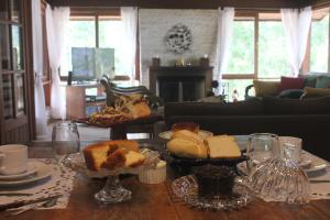 uma mesa com diferentes tipos de pão e pastelaria em Bendito Recanto em Penedo