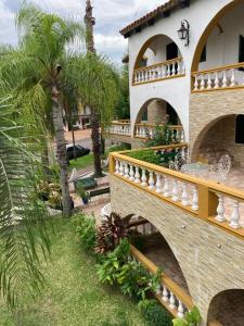 uma casa com uma ponte e uma palmeira em Casablanca Termal Apart-Hotel em Termas del Daymán
