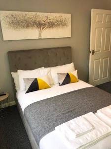 a bedroom with a bed with yellow and black pillows at Coastal Retreat - Skegness in Skegness