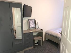 1 dormitorio con escritorio, espejo y cama en Coastal Retreat - Skegness en Skegness