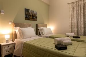 a bedroom with two beds and a table with a lamp at UniQApt in Corfu Town