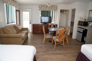 a living room with a couch and a table and chairs at Daytona Dream Inn By AmeriVu in Daytona Beach