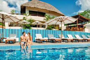 Ein Mann und eine Frau sitzen im Pool eines Resorts. in der Unterkunft Grand Matlali Riviera Nayarit in La Cruz de Huanacaxtle