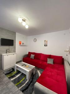 un salon avec un canapé rouge et une télévision dans l'établissement Bele Staze Kopaonik s, à Brzeće