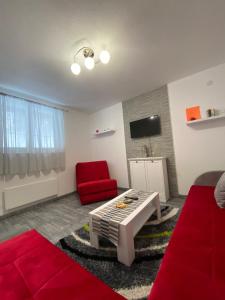 ブルゼーチェにあるBele Staze Kopaonik sのリビングルーム(赤いソファ、赤い椅子付)