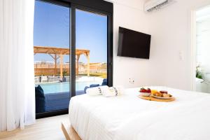 a bedroom with a bed with a plate of fruit on it at Sardines Luxury Villas in Analipsi