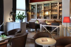 a restaurant with chairs and tables and a bar at Ambassador Hotel in De Panne