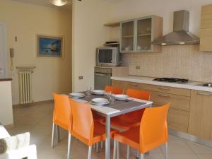 una cucina con tavolo da pranzo e sedie arancioni di Belvilla by OYO Argentina Cinque a Lazise