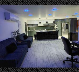 a living room with a blue couch and a kitchen at The Villas Beach House in Rosarito
