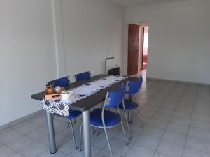 a long table with blue chairs in a room at Departamento Céntrico Las Estaciones in Sunchales