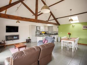 a living room with a couch and a table at 1 Beacon View Barn in Felindre