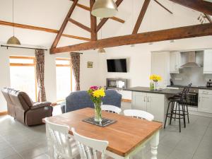 a kitchen and living room with a wooden table and chairs at 1 Beacon View Barn in Felindre