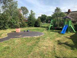 a yard with a playground with a swing at Großzügiges Reetdachhaus an der Nordsee in Langenhorn