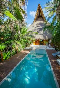 uma piscina em frente a um edifício com palmeiras em All inclusive beachfront villa in Sian kaan em Tulum
