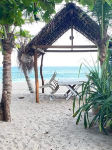 a picnic table and a chair on the beach at Simple Place in Mirissa