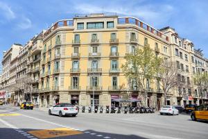 a large yellow building on a city street with cars at Sonder Vasanta in Barcelona
