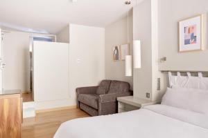 a bedroom with a bed and a chair at Sonder Vasanta in Barcelona