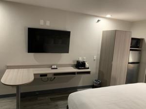 a hotel room with a bed and a television on the wall at Microtel Inn and Suites Clarksville in Clarksville