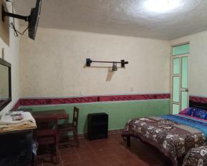 une chambre avec un lit, un bureau et une table dans l'établissement El Portón de Cortés, à Tepeaca