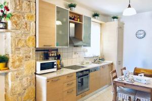 a kitchen with wooden cabinets and a table and a microwave at Beach Stone Mezonete 5min from the Golden Xenia beach in Paliouri