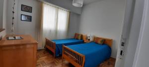1 dormitorio con 2 camas, escritorio y ventana en ALMAR III Sólo para familias en Mar del Plata