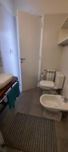 a bathroom with a white toilet and a sink at ALMAR III Sólo para familias in Mar del Plata