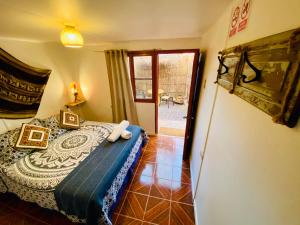 a bedroom with a bed in a room with a window at Posada Atacameña in San Pedro de Atacama
