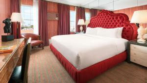 a large bed with a red headboard in a hotel room at Maison 140 Beverly Hills in Los Angeles