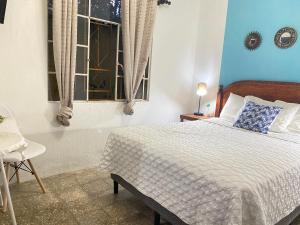 a bedroom with a bed and a dresser at Hostal Casa Tenango in Cobán