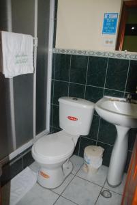 a bathroom with a toilet and a sink at D’ RUIZ HOTEL in Quevedo
