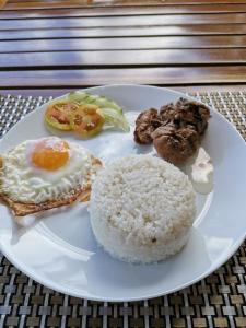 a plate of food with eggs and rice on a table at Layang Layang Home in El Nido