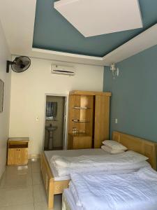 a bedroom with two beds and a blue ceiling at Trúc Linh Mộc Châu Hostel in Mộc Châu