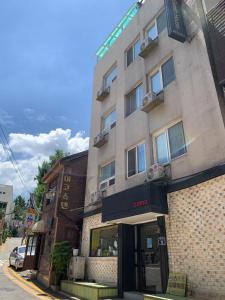 a building on a city street with a store at Myeongdong Guesthouse Como in Seoul