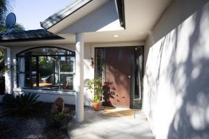 a front porch of a house with a patio at Palm Garden Papamoa Beach Paradise in Papamoa