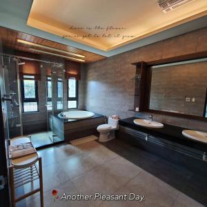 a bathroom with a tub and a toilet and a sink at Dibao 16 Homestay in Fang-liao