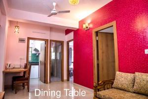 a living room with a red wall and a couch at Ruby by Olys Apartment in Kolkata