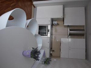 a kitchen with white cabinets and a bunch of dishes at Apartament Lawendowy in Jastrzębia Góra
