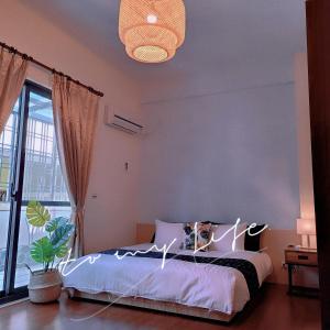 a bedroom with a bed and a large window at Dibao 16 Homestay in Fangliao