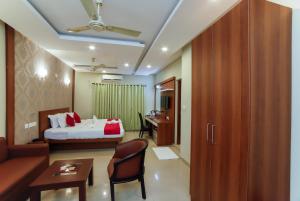 Una habitación de hotel con una cama, un sofá y un escritorio. en Sreepathi Indraprastha, en Guruvāyūr