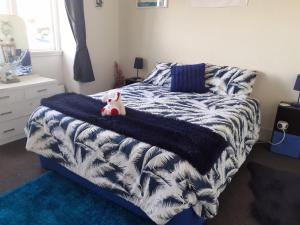 a bedroom with a bed with a blue and white blanket at Ellie's Villa in Brydone