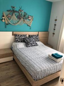 1 dormitorio con 1 cama con pared azul en Llançà piso muy tranquillo Llança appartement très tranquille Llançà flat very calm, en Llançà