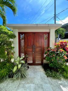 a house with a wooden door and some flowers at Villa Capella in Canggu