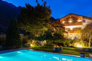 uma villa com piscina à noite em Garni Hotel Am Meilenstein em Rabla