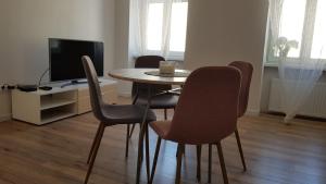 einen Tisch und Stühle im Wohnzimmer mit TV in der Unterkunft Avalon apart 1 in Legnica