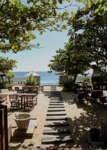 a patio with tables and chairs and the ocean at Bay Vista in Arugam Bay