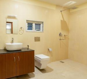 un bagno con lavandino, water e specchio di Everland Kathmandu Hotel a Kathmandu